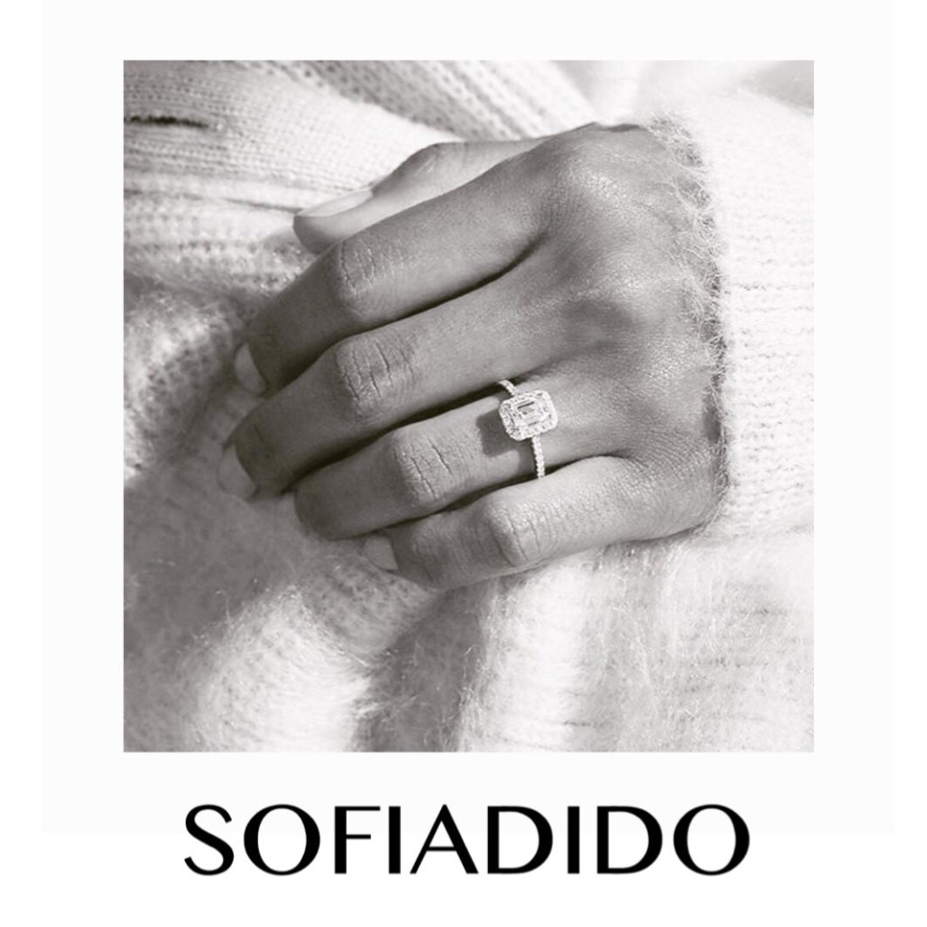SOFIADIDO emerald-cut halo ring on a hand resting on white knitwear