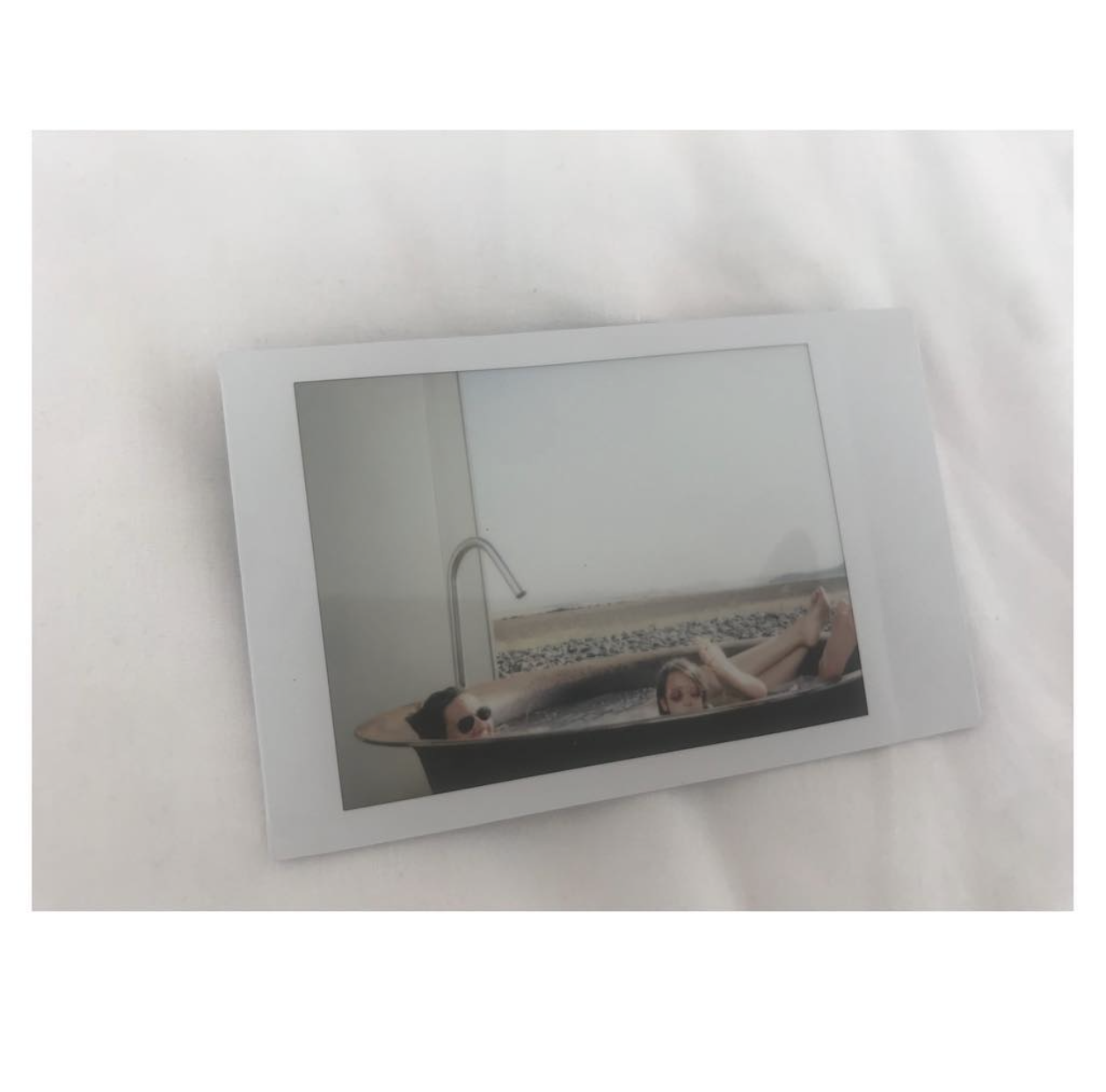 Polaroid of a woman reclining in a bath